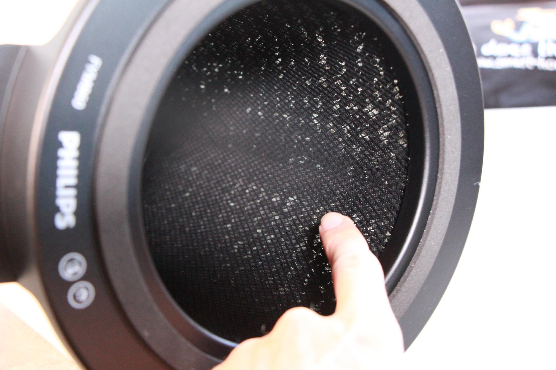 Der Aktivkohlefilter auf der Innenseite des Kombifilters vom Philips Air Performer 7000 Luftreiniger wird in der Hand gehalten.